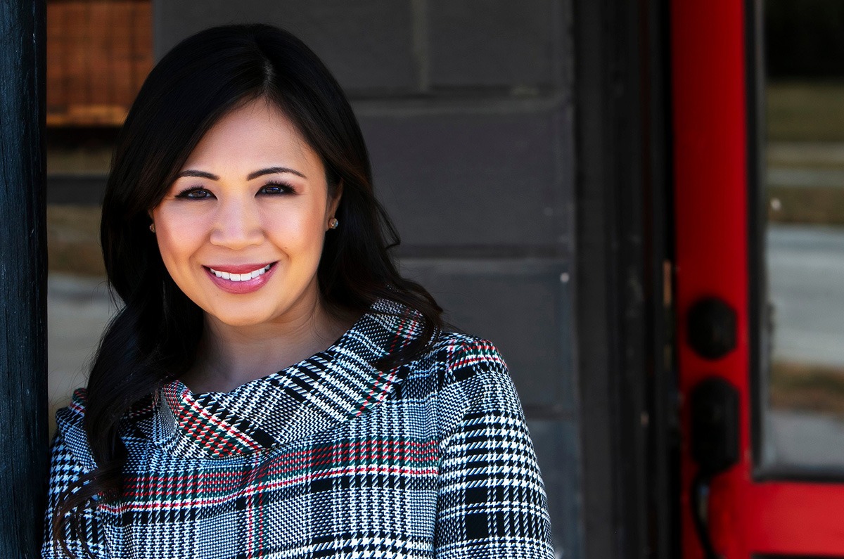 Dr. Beverly Moon, Olathe cosmetic dentist, smiling in a stylish coat, showcasing her commitment to enhancing smiles through cosmetic dentistry.