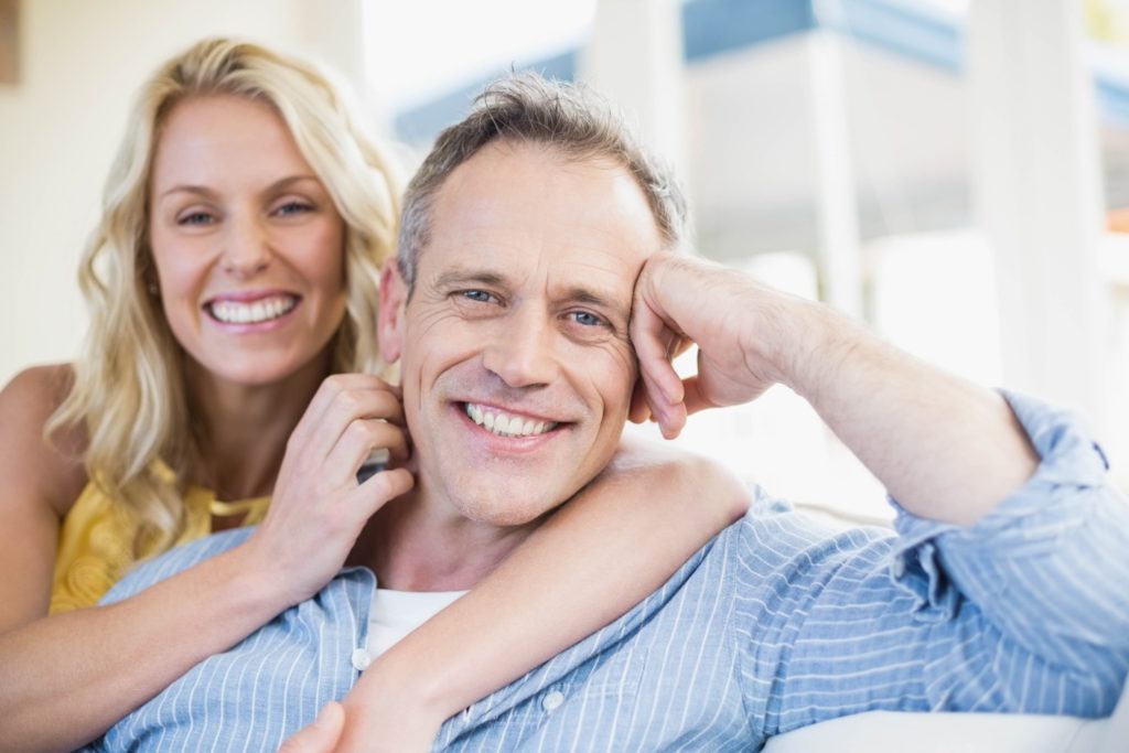 Smiling couple embracing, representing family dentistry and cosmetic dentistry services at Moon Signature Dentistry in Lenexa.